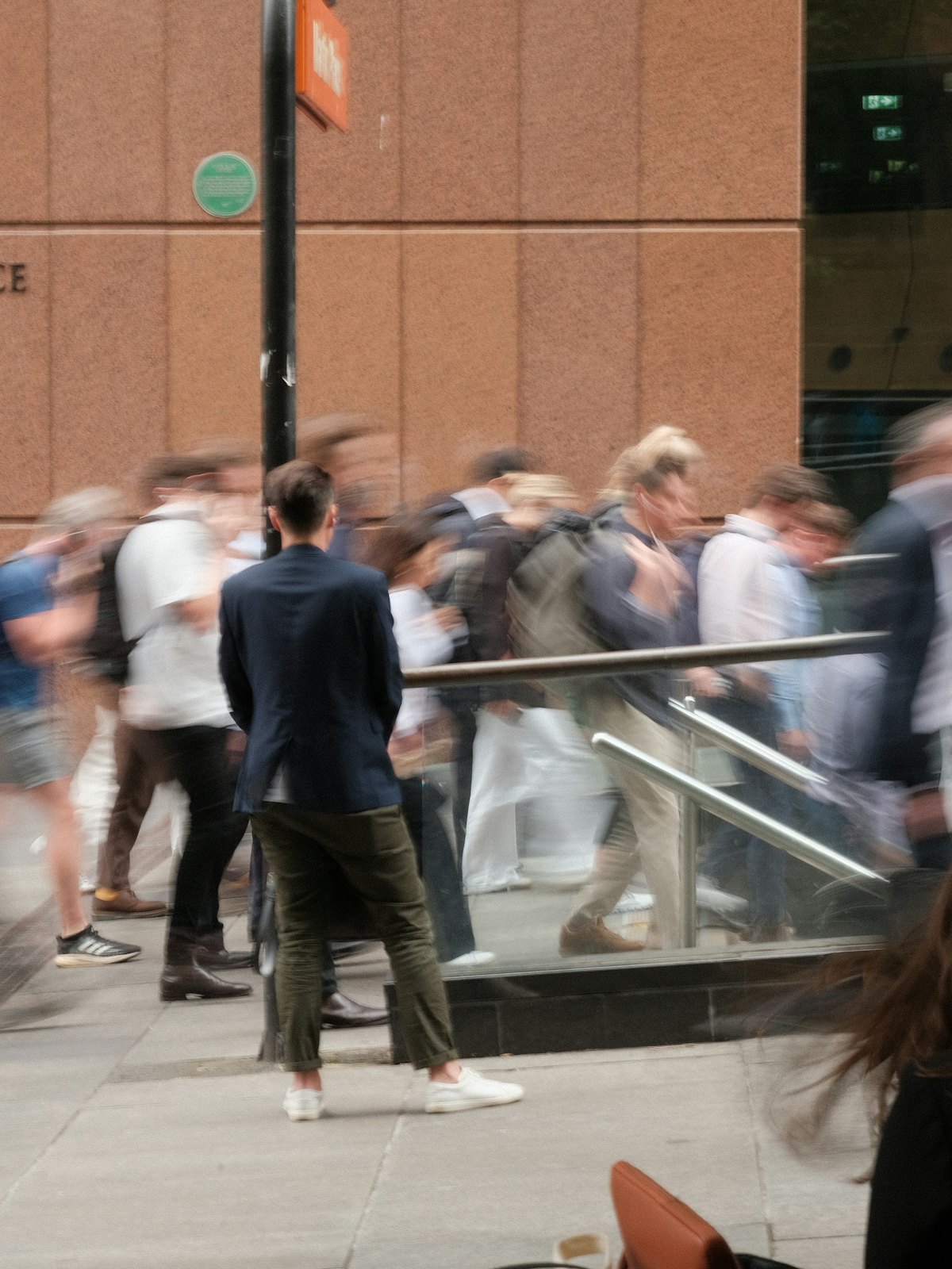 People crossing a plaza in motion outside an office building
