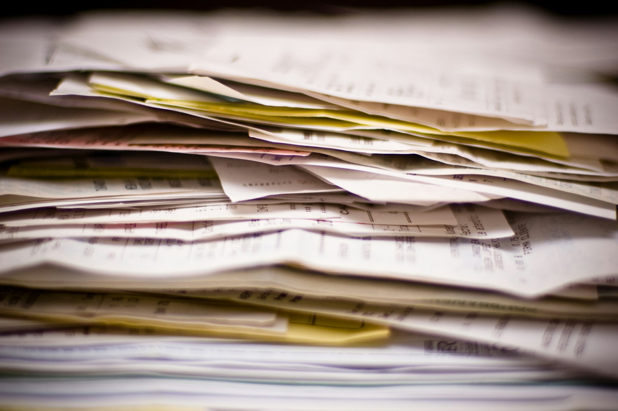 A thick stack of invoices and paper records seen side-on