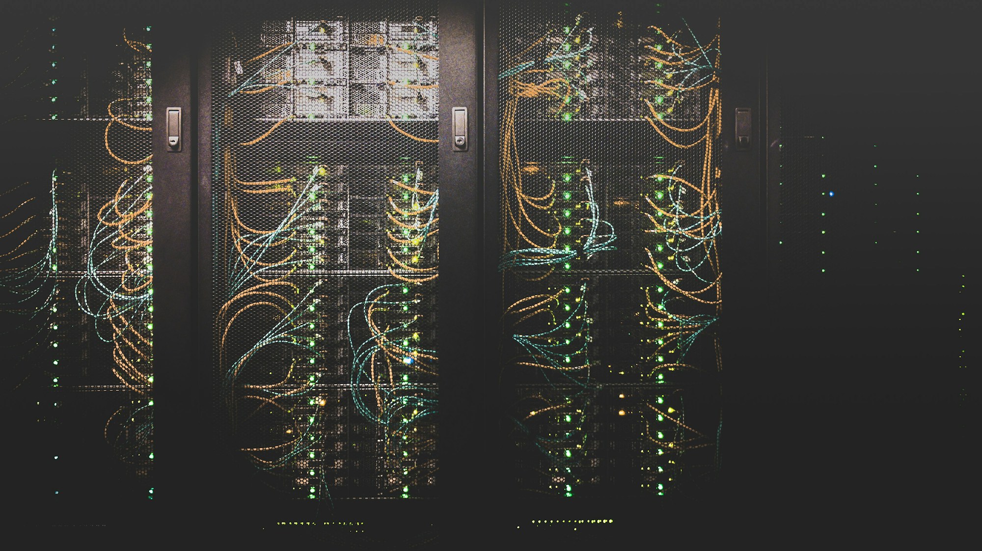 Network cables patched into server racks in a dark data centre